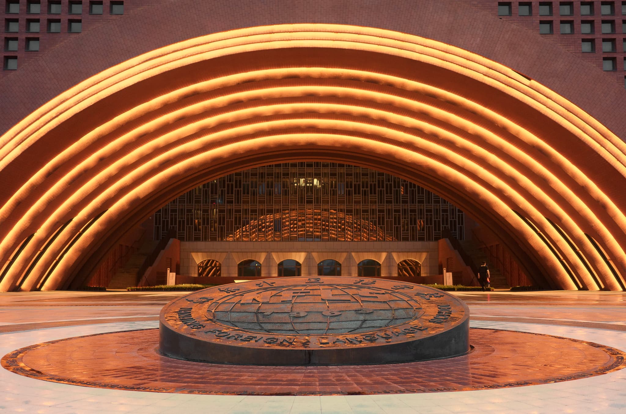 Concentric illuminated arches frame a large indoor atrium with a circular fountain at center