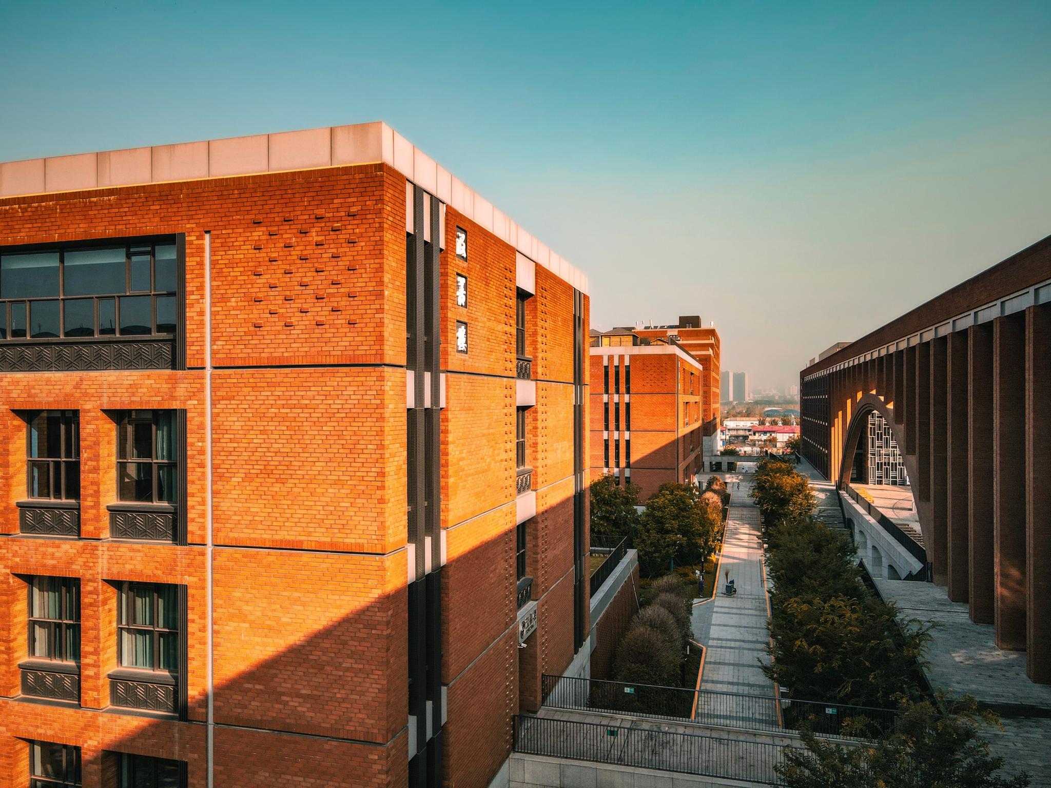 A cityscape during golden hour featuring modern brick buildings and a clear sky